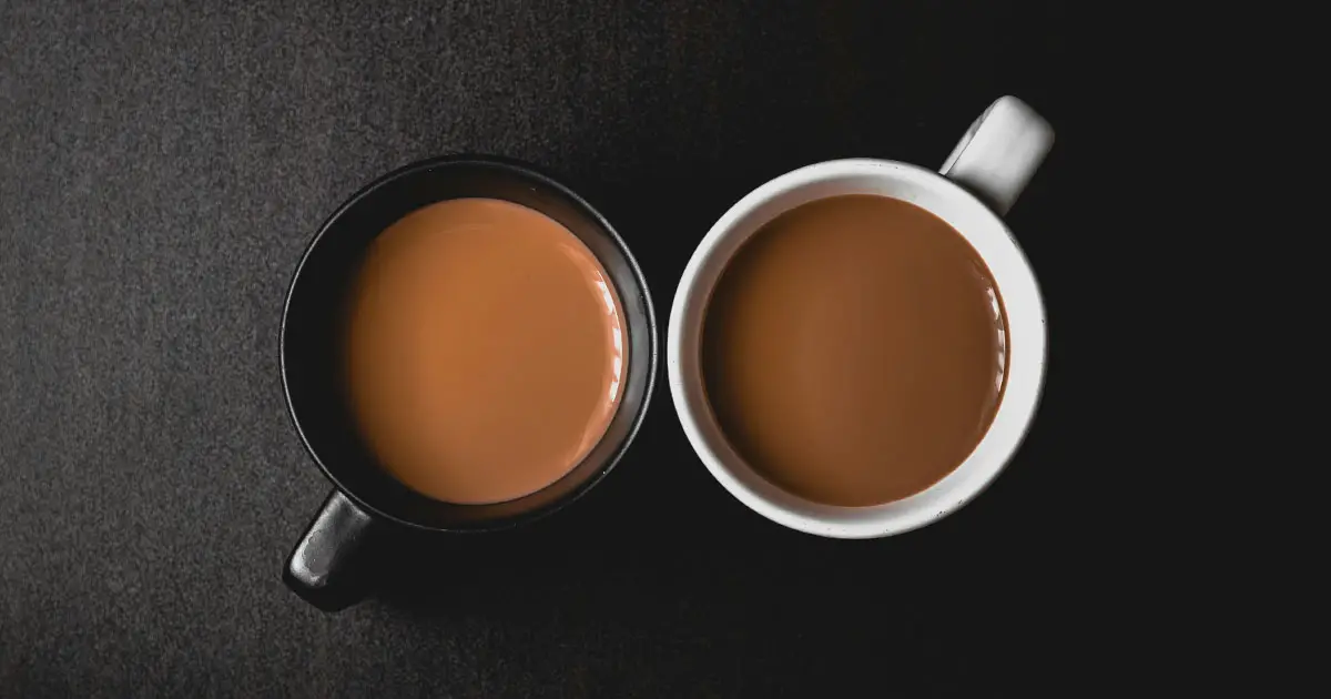 two cup of coffee with black cup and white cup 