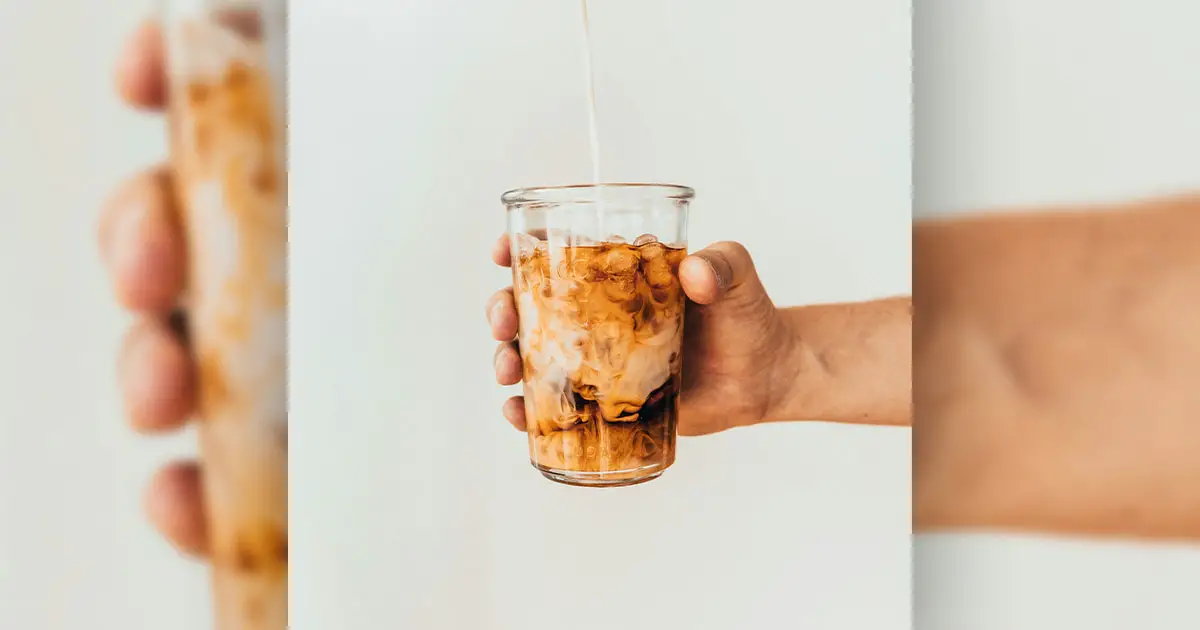 a man holding a cup of iced coffee